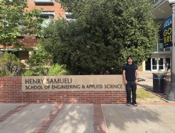 Anand beside the sign for UCLA’s Henry Samueli School of Engineering