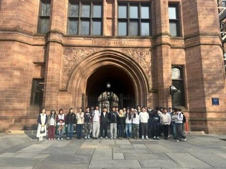 A college tour group posed in front of Shields Hall