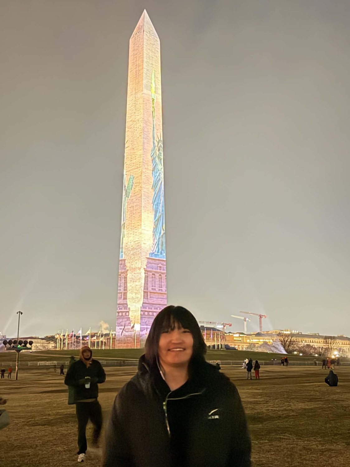 Anand standing in front of the illuminated Washington Monument at night